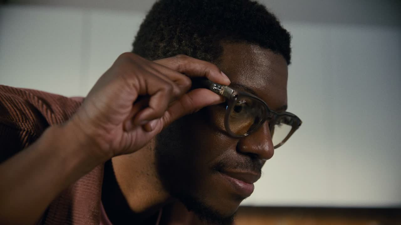 Homem a ajustar óculos Ray-Ban Meta de armação castanha