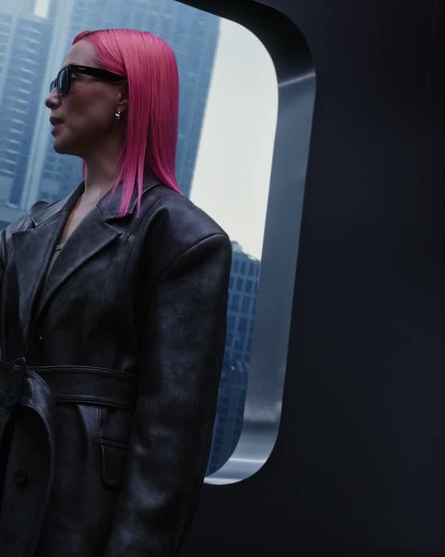 Mulher de cabelo rosa com óculos Ray-Ban Meta a olhar para a cidade